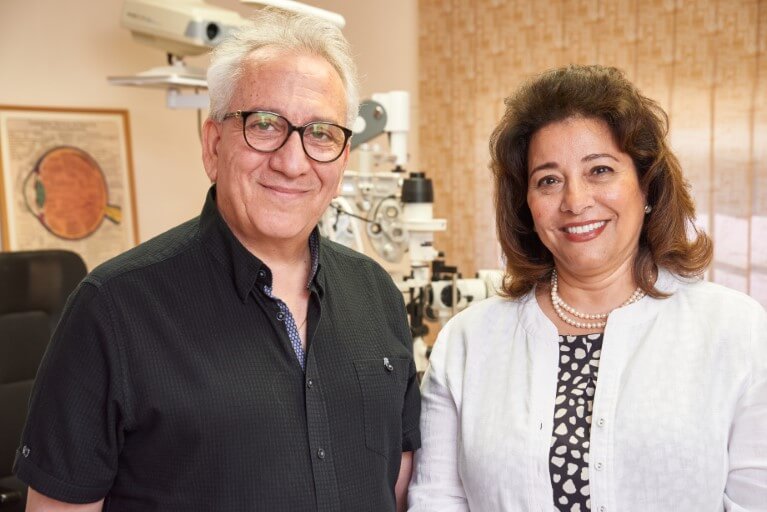 Drs. Bassem Fawzy & Tereza Fawzy standing next to one another, smiling, in their practice.
